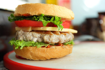 Cooking of burgers with veal, red tomatoes, lettuce, cheese and sauce in the home kitchen