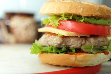 Cooking of burgers with veal, red tomatoes, lettuce, cheese and sauce in the home kitchen