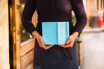 Woman's hands holding blue notebook with empty space for text