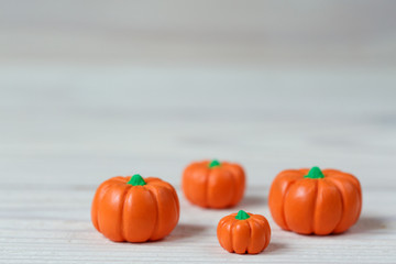 Little polymer clay pumpkins on white wooden background