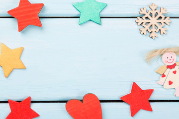 Christmas decorations red, yellow stars, angel, snowflake and heart on light blue wooden background. Copy space for your text. Can be used as christmas card.