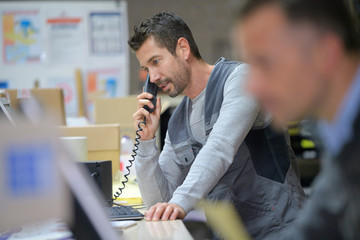 businessman on phone at warehouse - obrazy, fototapety, plakaty