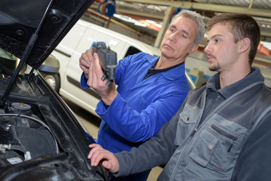 auto mechanic teacher and trainee performing tests at mechanic school