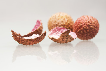 Litchi peeled fruit and peels on white background
