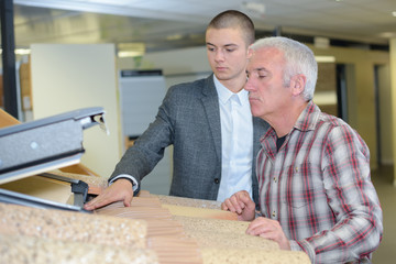 salesman showing customer velux roof window in showroom