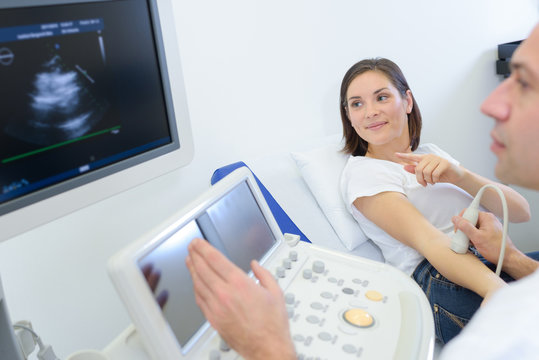 woman pointing to ultrasound image of her arm