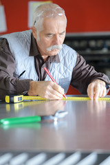 positive efficient working man measuring boards for furniture at workshop
