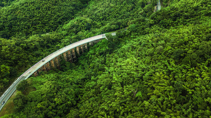 An aerial view of  Road or bridge is in the middle of a forest