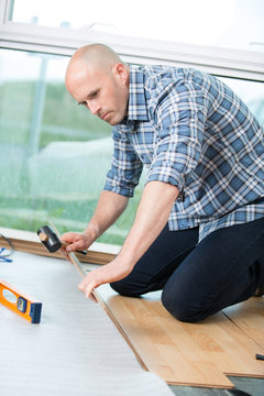 man installing new laminated wooden floor