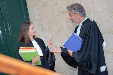 Two legal workers talking, wearing robes