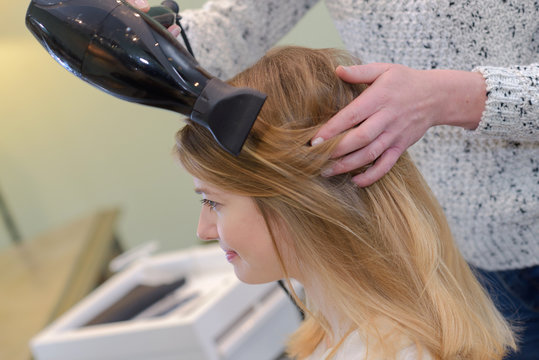 hairdresser blow drying hair
