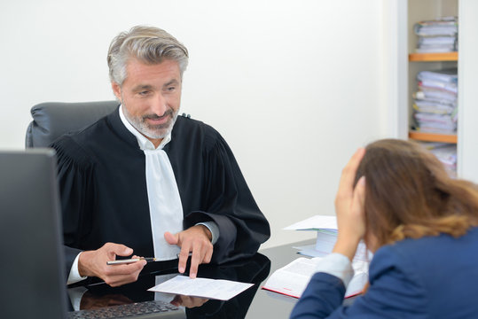 Client with head in hands talking to lawyer