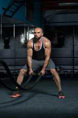Fototapeta na wymiar Battling Ropes Young Man At Gym Workout Exercise