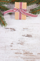 Wrapped gift and spruce branches for Christmas or Valentines, copy space for text on rustic board