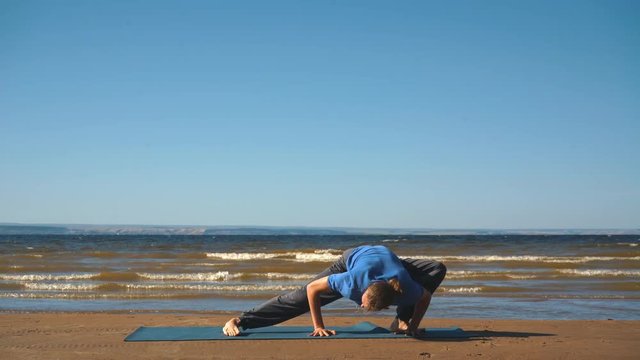 Athletic muscular young man working out, yoga, goddess, sumo wrestler pose