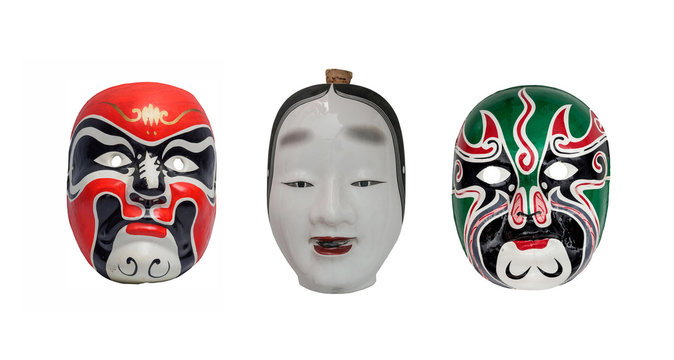 Two colorful  and one ceramic face of Traditional japanese theater masks made of wood on white background