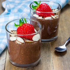 Chocolate chia seed pudding garnished with almond slices and strawberry, square format