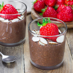 Chocolate chia seed pudding garnished with almond slices and strawberry, square format