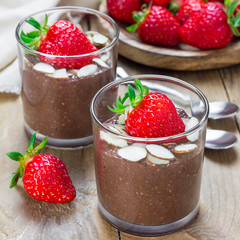 Chocolate chia seed pudding garnished with almond slices and strawberry, square format