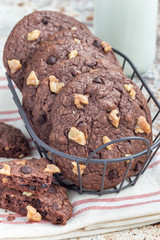 Homemade chocolate cookies with walnuts and chocolate chips in metal basket, vertical