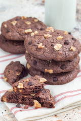 Homemade chocolate cookies with walnuts and chocolate chips on table, vertical