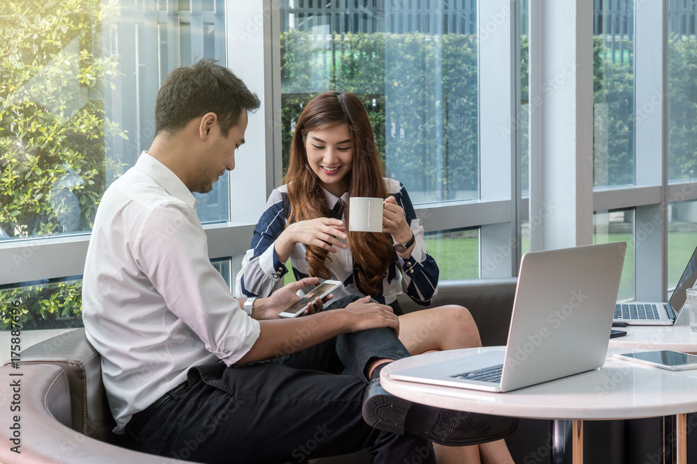 Wall mural Closeup Happy Asian Beautiful young business woman talking with businessman with formal suits in modern office, business people concept