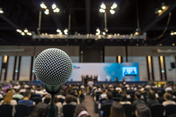 Microphone with Abstract blurred photo of conference hall or meeting room with attendee background,...