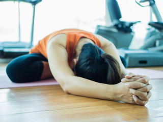 Closeup woman training yoga with fitness equipment background, sport, people and healthy lifestyle concept.