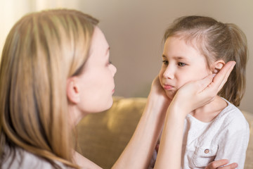 Beautiful mother is comforting his young frustrated daughter.
