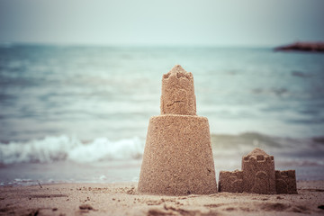 Persistent tower of the sand castle washes away in the sea water.
