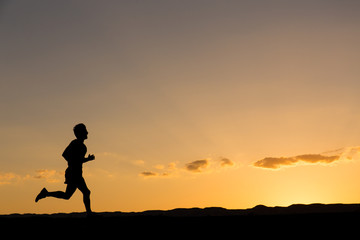 Silhouette of a man running at sunset