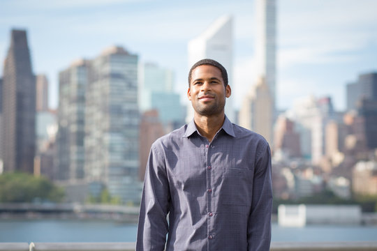 Portrait of young handsome African American man with NYC skyline in the background