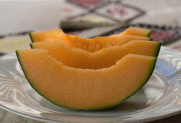 close up sliced  cantaloupe on white plate