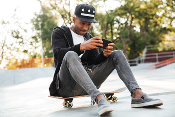 Portrait of an african guy playing on mobile phone