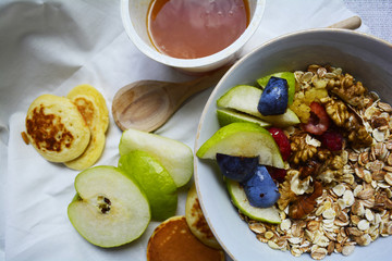 hearty Breakfast, fruit muesli for Breakfast with honey and pancakes on the table