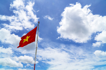 Vietnamese flag under blue and cloudy sky