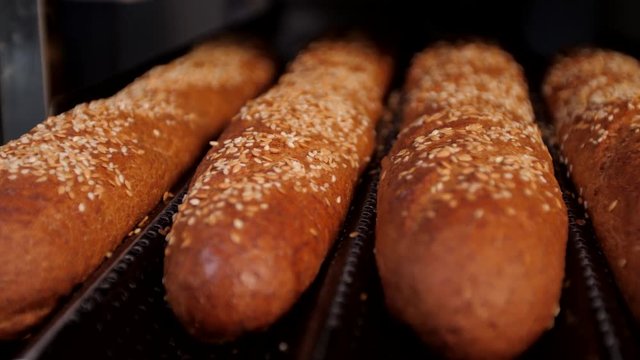 Rows of fresh bread loafs lying on the shelf.