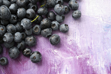 Fresh healthy berries of blueberries on lilac abstract canvas