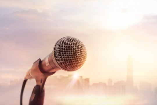 Microphone on stage on warming sunset city background