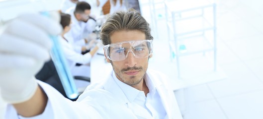 tube with reagents on blurred background laboratory.