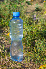 Plastic bottle of drinking water on the ground