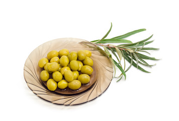 Green olives on saucer and olive branch