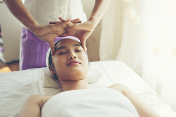 Fototapeta na wymiar Young beautiful woman having face massage relaxing in spa.