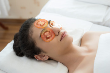 Obraz na płótnie Canvas Young woman with fresh tomatoes mask in spa.