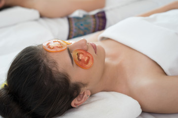 Obraz na płótnie Canvas Young woman with fresh tomatoes mask in spa.