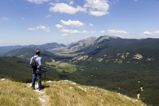 hiker in mountain landscape valley and lake