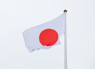 developing the flag of Japan against a gray sky
