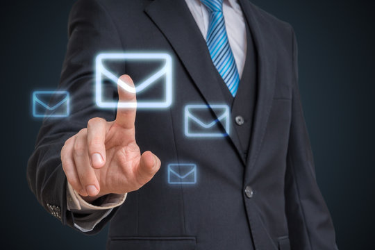 Businessman is touching mail symbol with finger on futuristic screen.