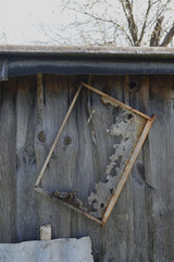 Old honeycomb frame hangs on the wooden barn wall
