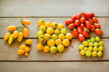 Multi-colored cherry tomatoes on wooden background.